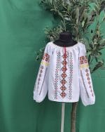 e tradițională moldovenească pentru fete, model Voiniceasca, albă cu broderie geometrică colorată și dantelă la gât.